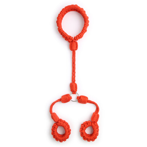 Flat-lay of bright red braided shibari handcuffs with two wrist loops and a connector loop