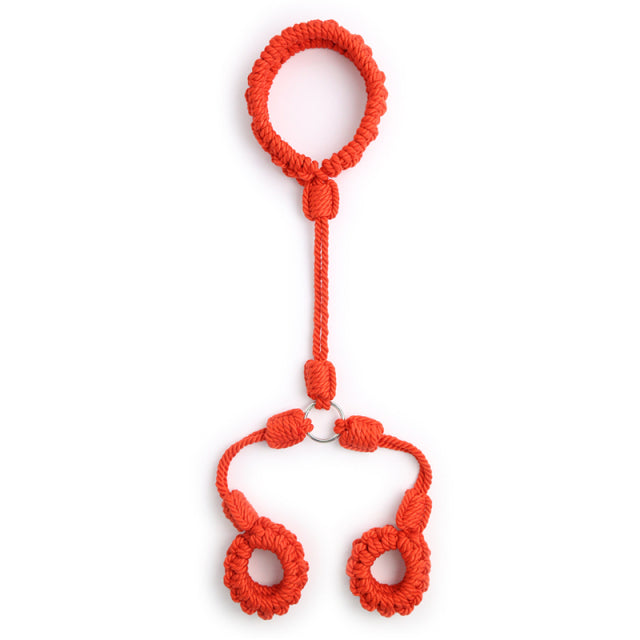 Flat-lay of bright red braided shibari handcuffs with two wrist loops and a connector loop