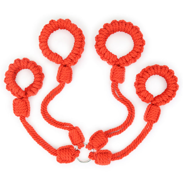Bright red braided shibari handcuffs arranged as two connected pairs on white