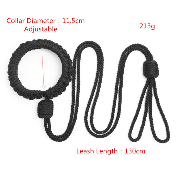 Black braided-rope shibari handcuffs arranged with a long connecting leash