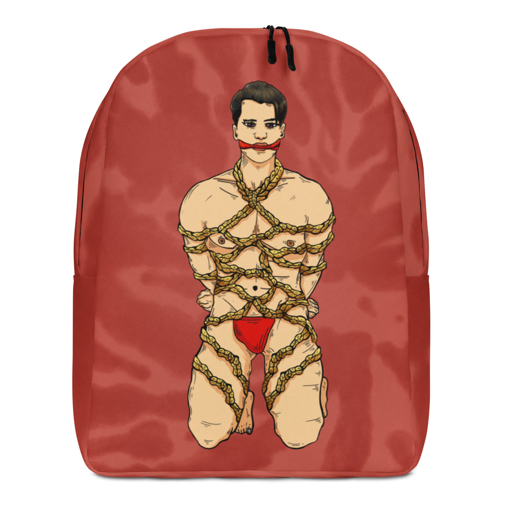 Front view of a red backpack printed with a bound, partially nude illustrated figure in rope and red underwear