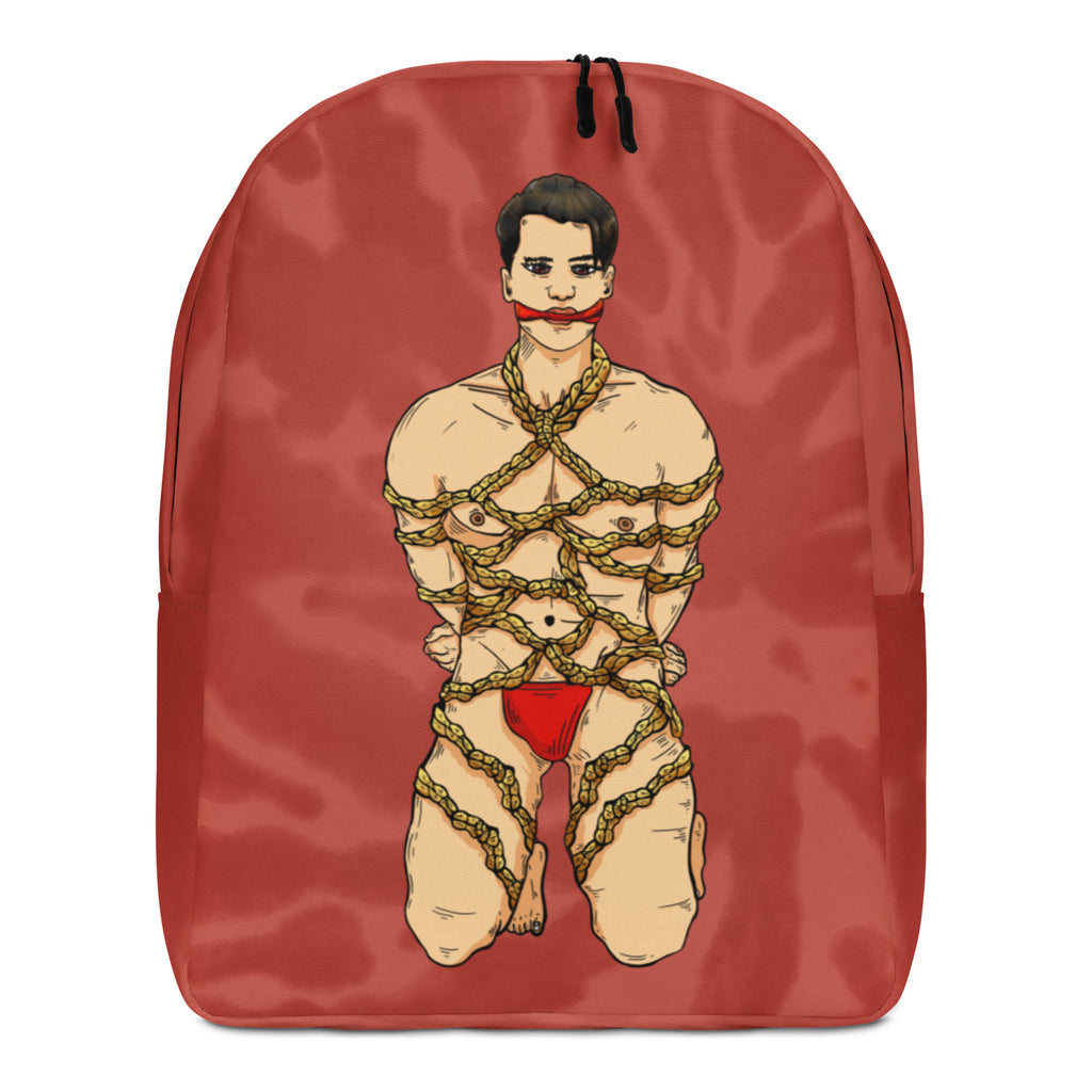 Front view of a red backpack printed with a bound, partially nude illustrated figure in rope and red underwear