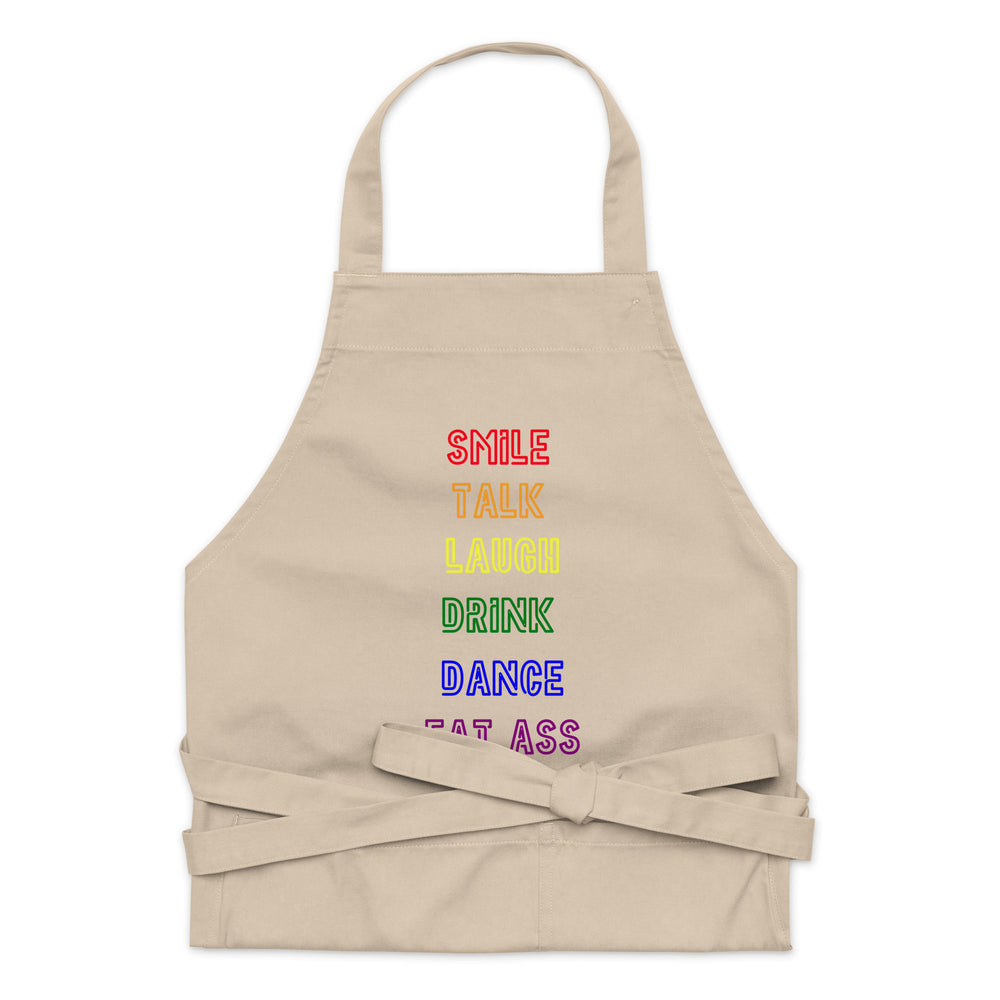 Beige apron with rainbow-colored “SMILE TALK LAUGH DRINK DANCE EAT ASS” lettering