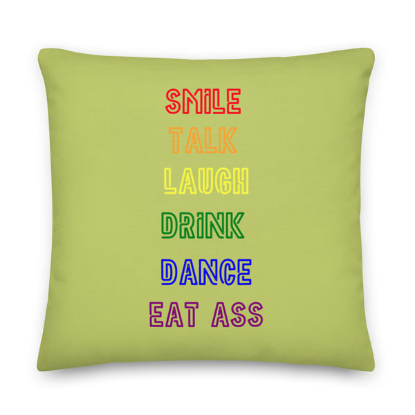 Square light-green pillow reading “SMILE, TALK, LAUGH, DRINK, DANCE, EAT ASS”