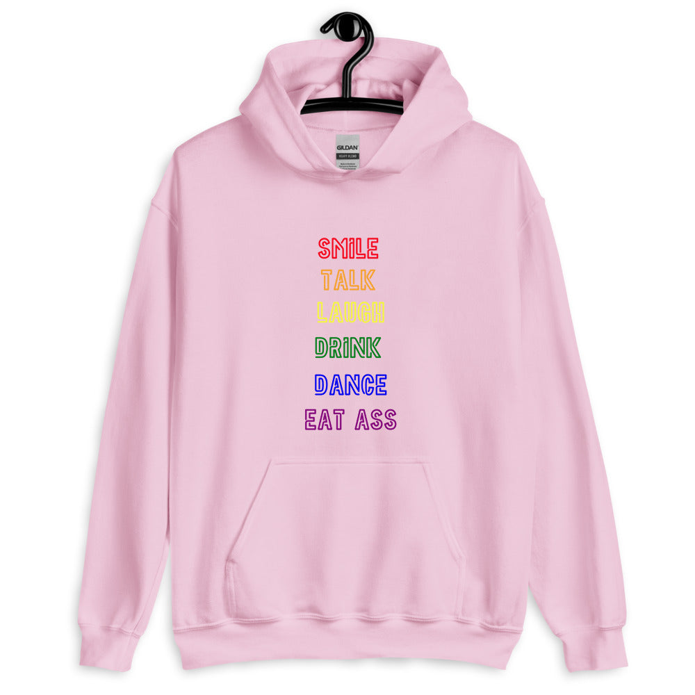 Front view of a pink pullover hoodie reading “SMILE TALK LAUGH DRINK DANCE EAT ASS.”