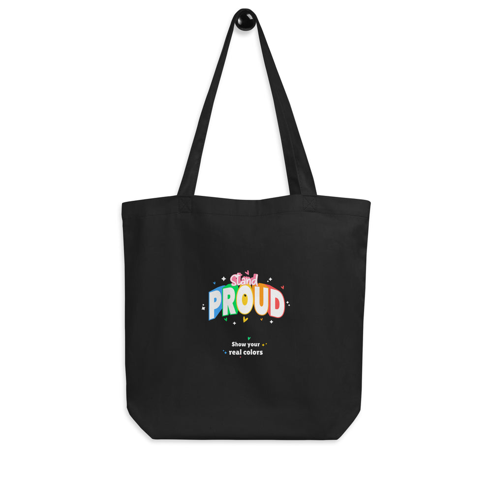 Front-facing black tote bag with colorful “Stand Proud” and “Show your real colors” text