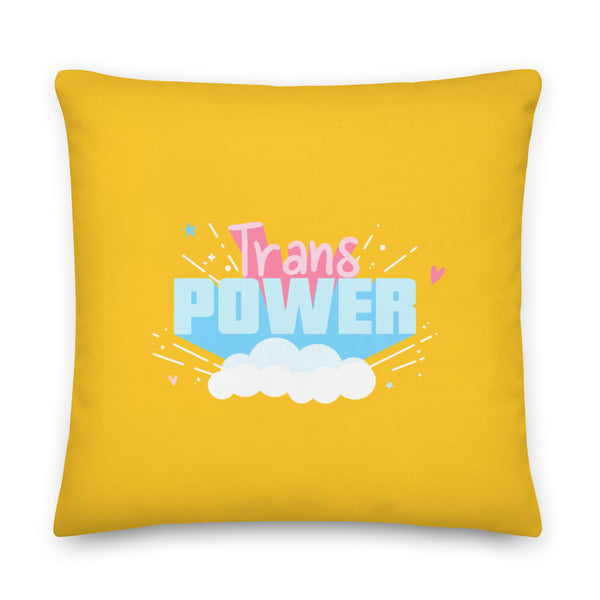 Yellow square pillow with colorful “Trans Power” lettering, clouds, stars, and hearts