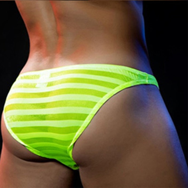 Close-up rear view of a model wearing sheer neon-green striped briefs