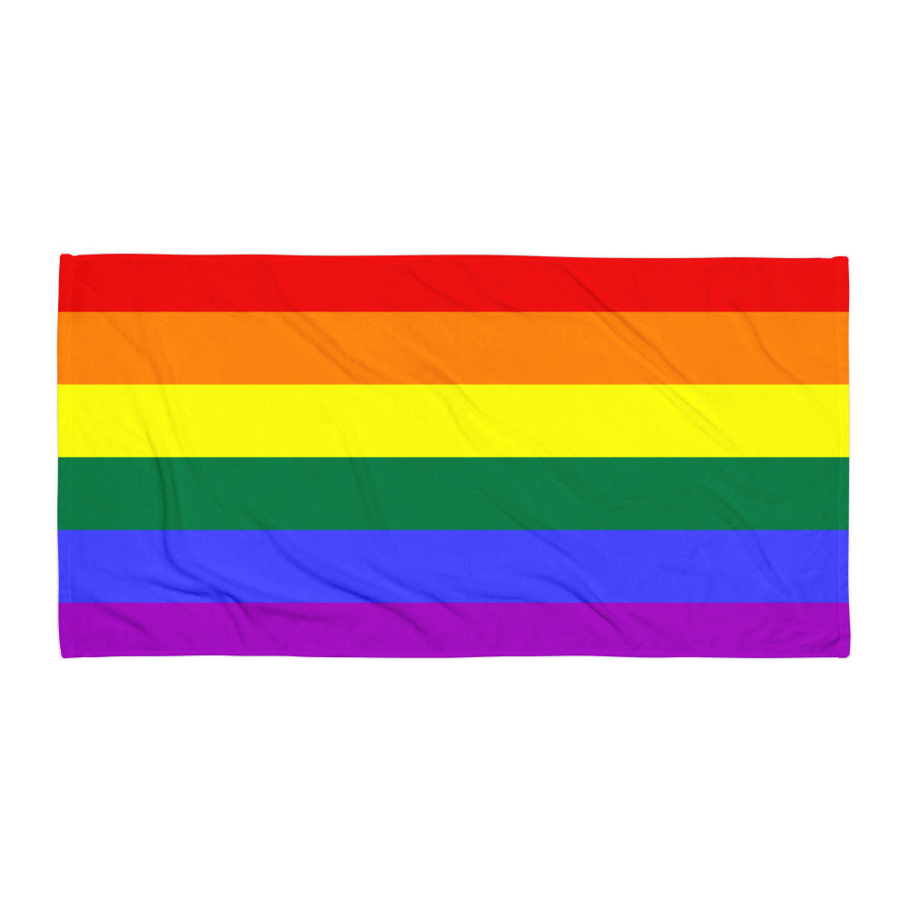 Gay Pride towel with bold, vibrant rainbow stripes hangs vertically on a backdrop of layered rainbow shapes for a true queer vibe.