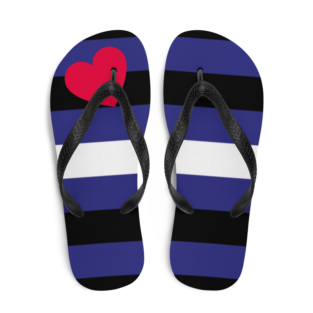 Top view of black, purple, and white striped flip-flops with a red heart