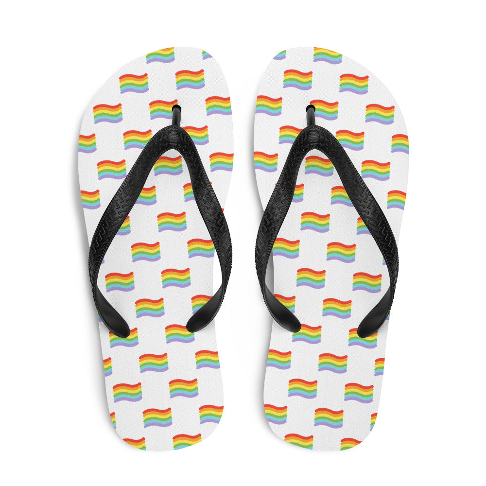 Pair of white flip-flops with black straps and repeated rainbow flag patterns
