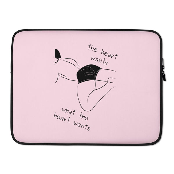 Pink laptop sleeve with black trim, reclining figure illustration, and “the heart wants what the heart wants” text