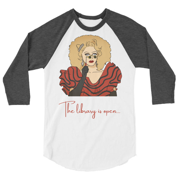 Front view of a white raglan shirt with dark gray sleeves and drag performer graphic reading “The library is open…”