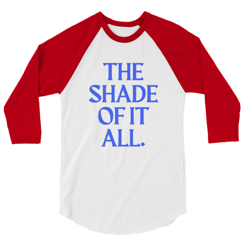 Front view of a white raglan shirt with red three-quarter sleeves and blue text, “THE SHADE OF IT ALL.”