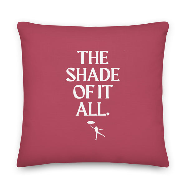 Square burgundy pillow with white “THE SHADE OF IT ALL.” lettering and umbrella figure