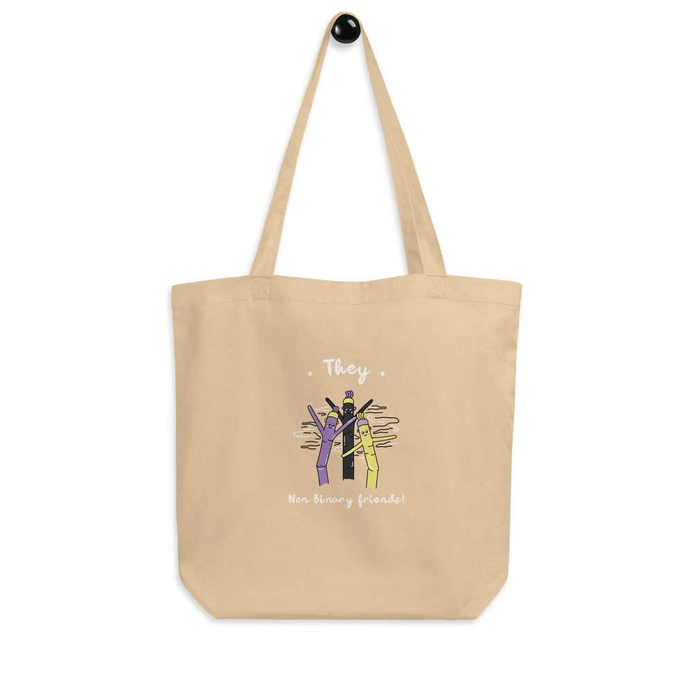 Front-view tan tote bag reading “They” and “Non-binary friends!” with three cartoon figures