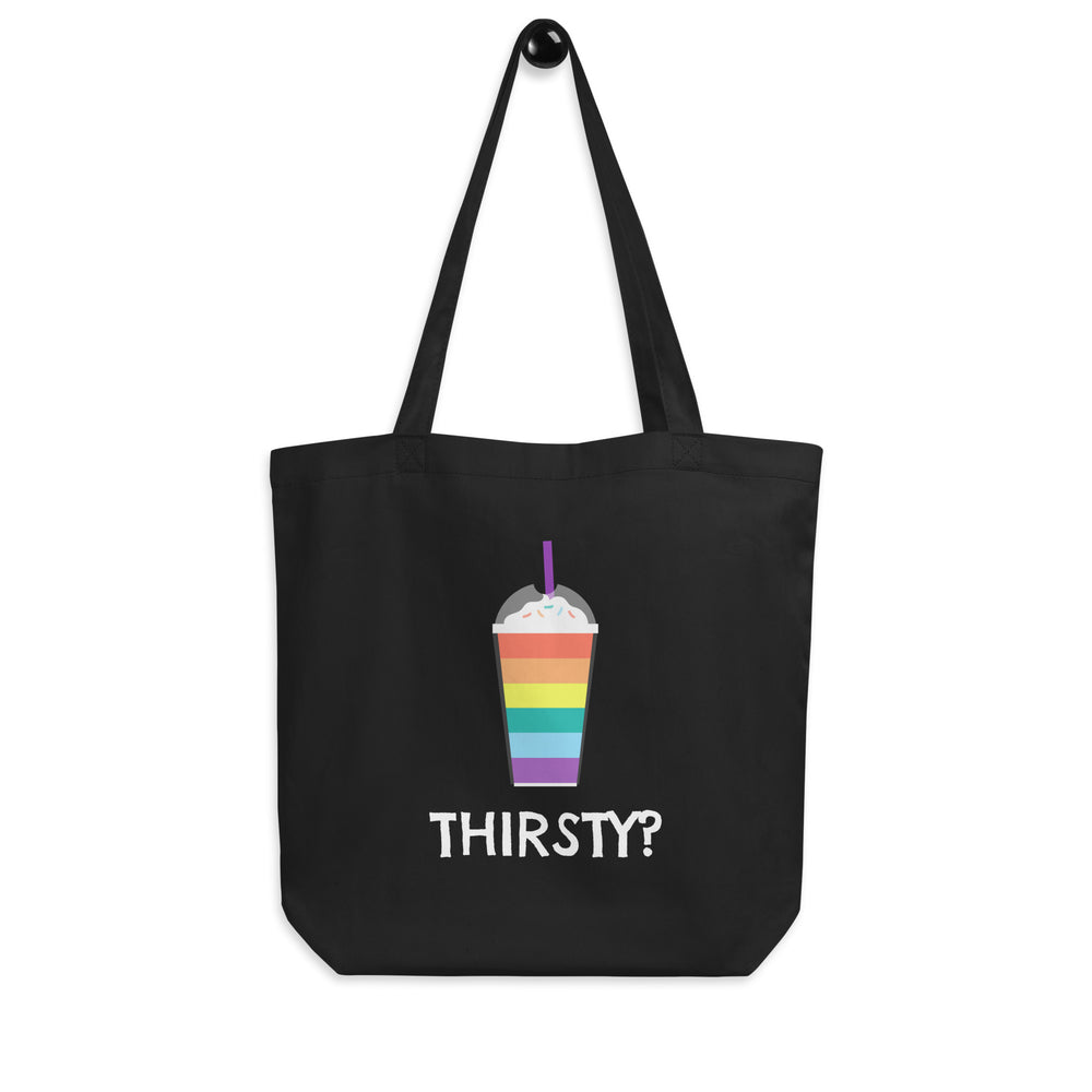 Front view of a black tote bag with a rainbow-striped drink and “THIRSTY?” in white lettering