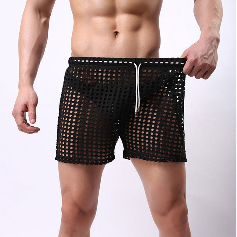 Close-up of a model wearing black see-through mesh shorts with a drawstring waist