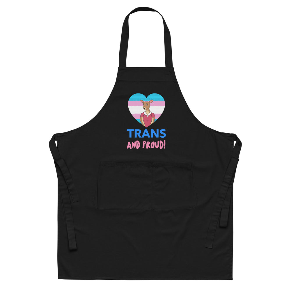 Front view of a black apron with a trans pride heart graphic and “TRANS AND PROUD!” text