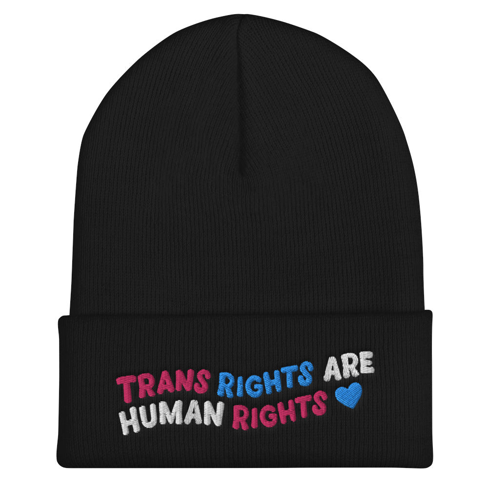 Front view of a black cuffed beanie reading “TRANS RIGHTS ARE HUMAN RIGHTS” with a blue heart