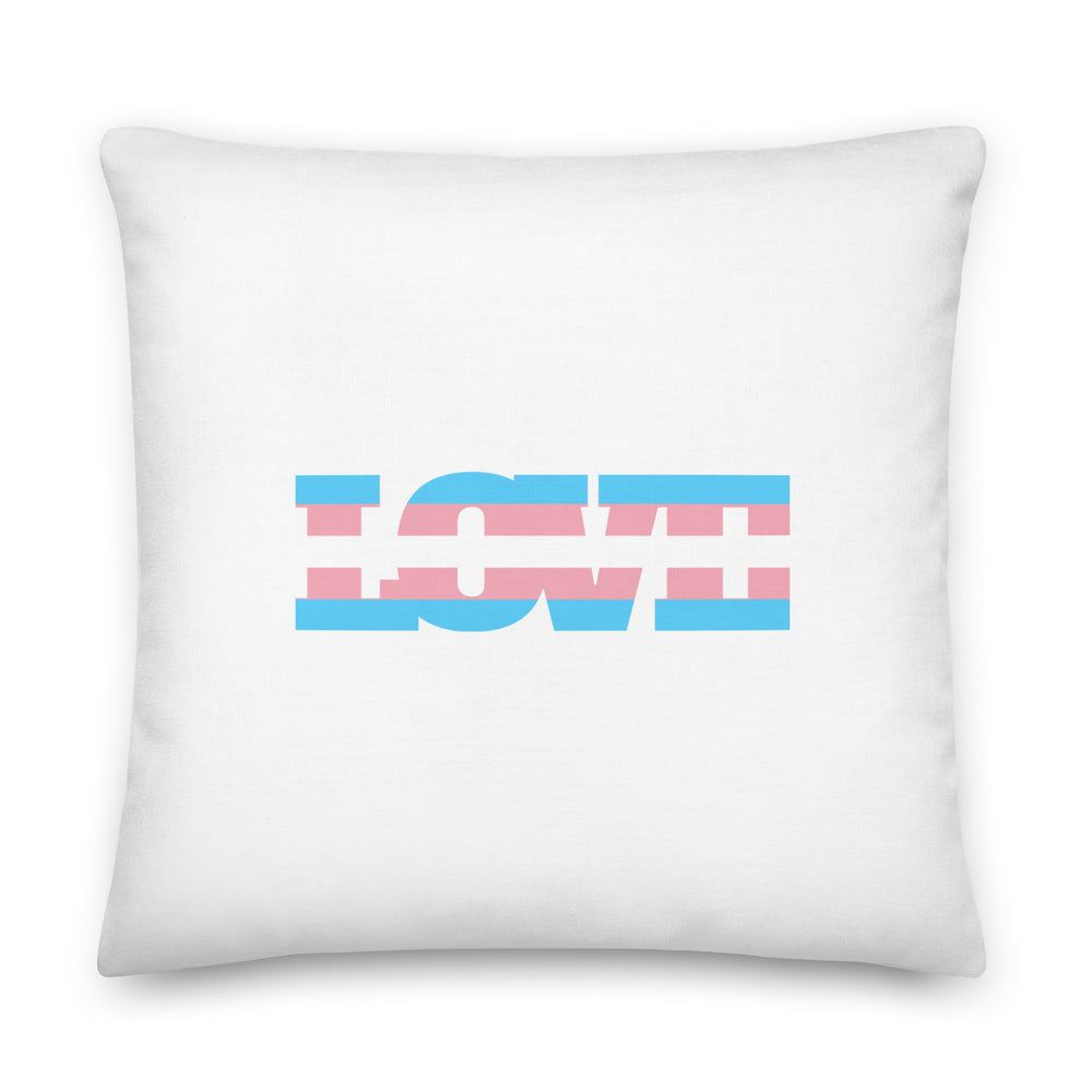 Transgender Love Pillow on a mat, “LOVE” in blue, pink, and white stripes evoking the trans flag; cozy queer living room vibes.