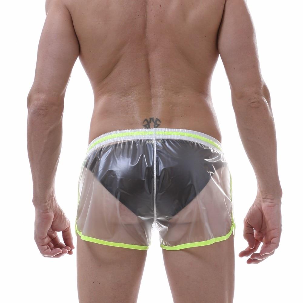 Rear view of a model wearing transparent black shorts with neon green trim