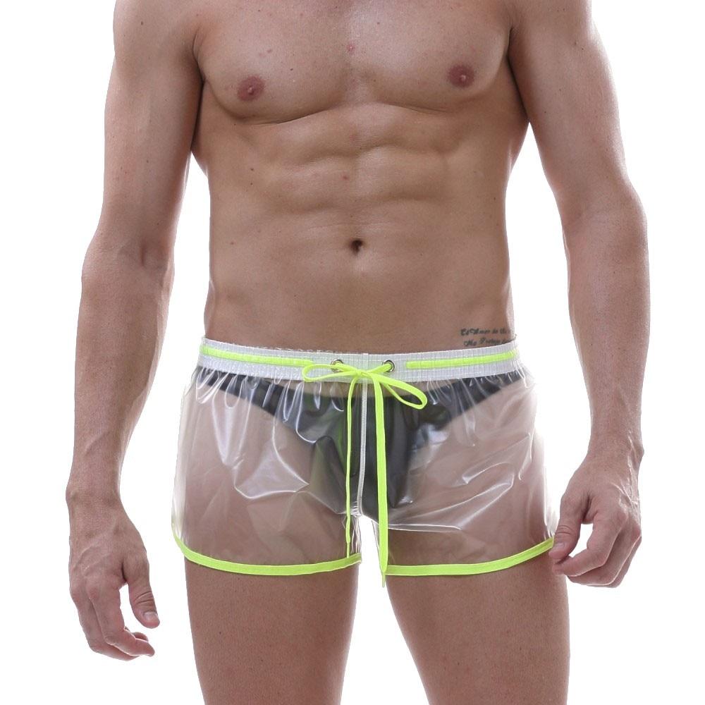 Transparent vinyl shorts with neon green trim, drawstring waist, and black pouch worn by a model