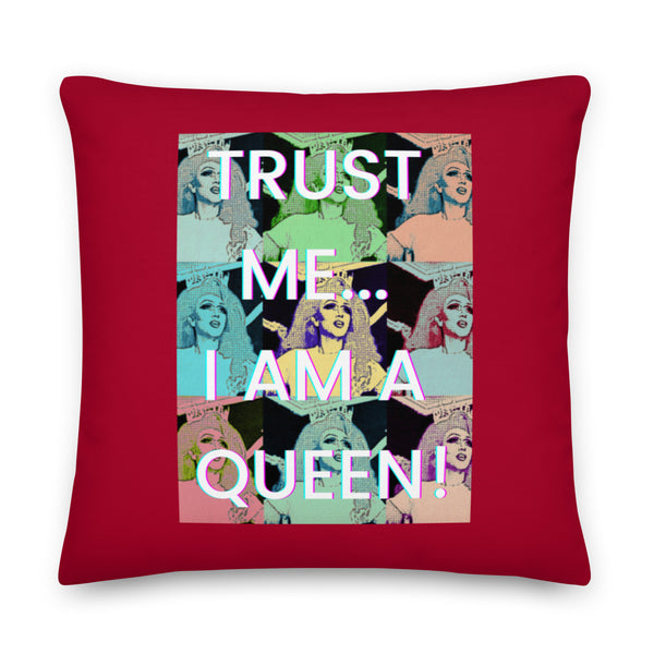 Front-facing red square pillow reading “TRUST ME... I AM A QUEEN!” over colorful portraits