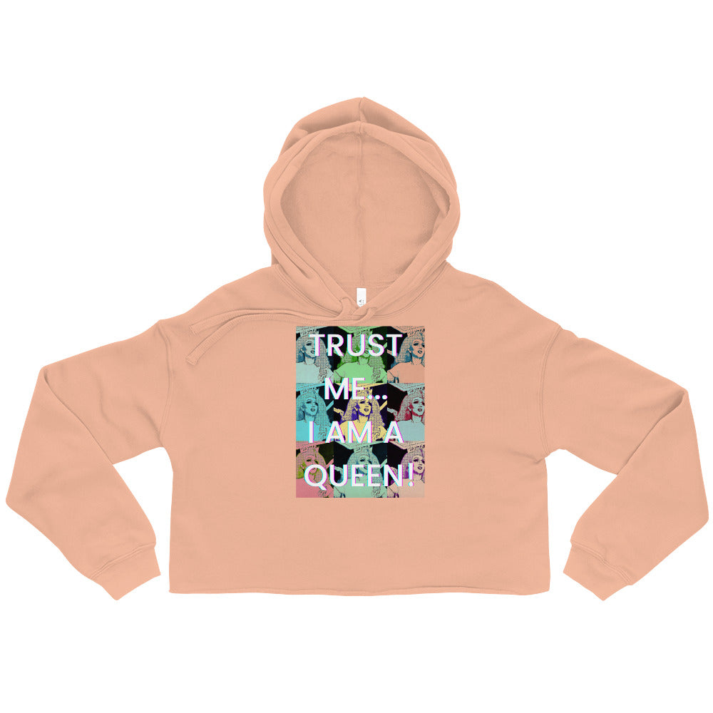 Front view of a peach cropped hoodie with a collage graphic reading “TRUST ME... I AM A QUEEN!”