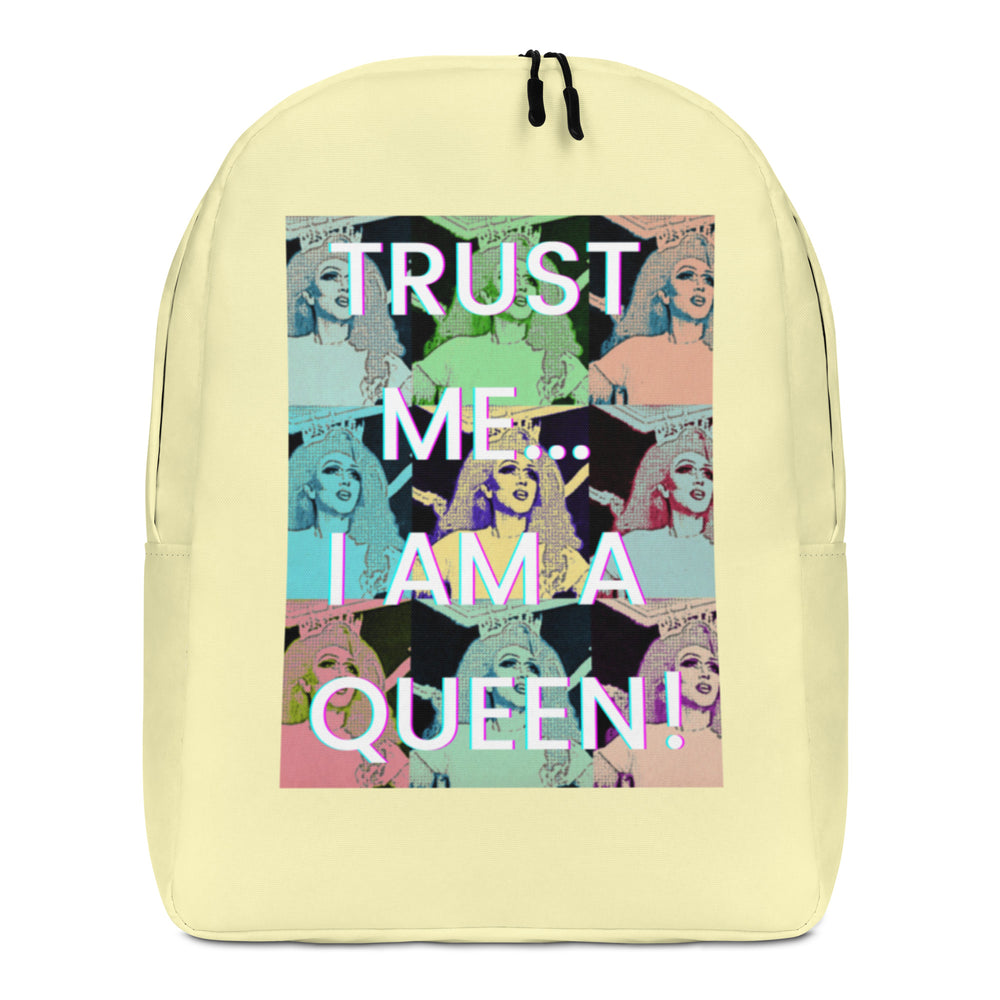 Front view of a pale yellow backpack with a colorful repeated queen portrait print and “TRUST ME... I AM A QUEEN!”