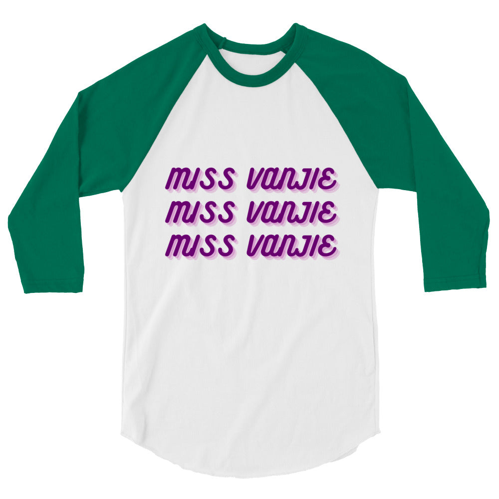 Front view of a white raglan shirt with green sleeves and repeated purple “Miss Vanjie” text