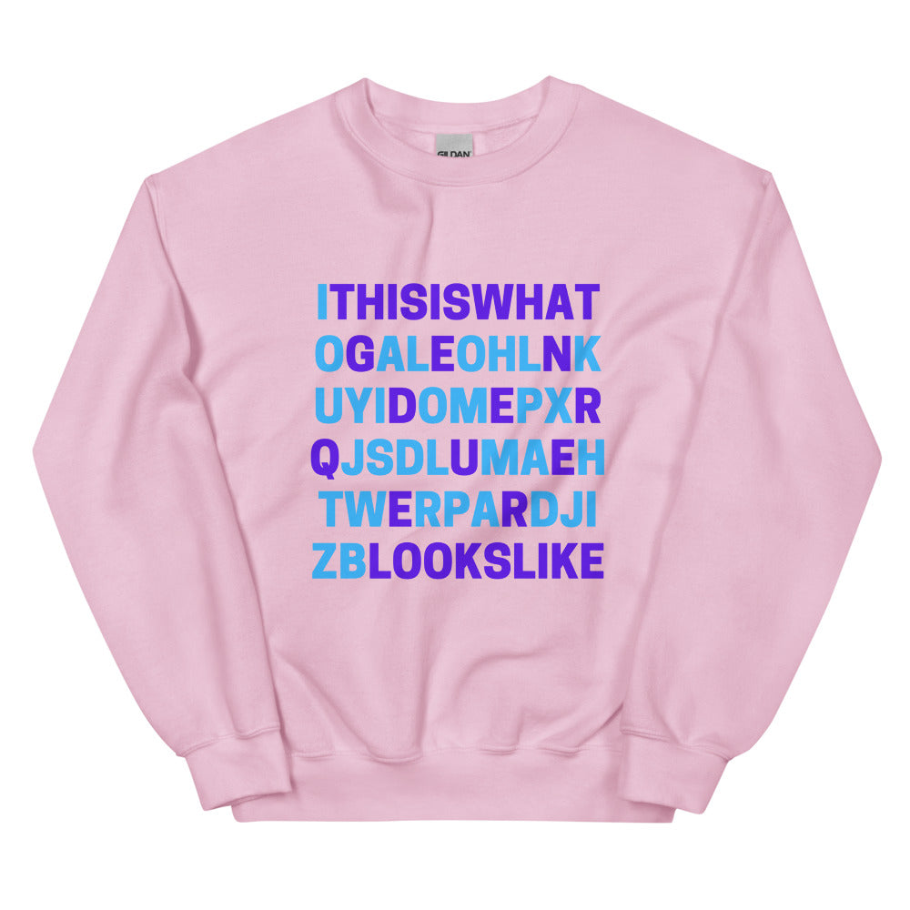 Front view of a pink sweatshirt with blue and purple text reading “THIS IS WHAT GENDERQUEER LOOKS LIKE.”