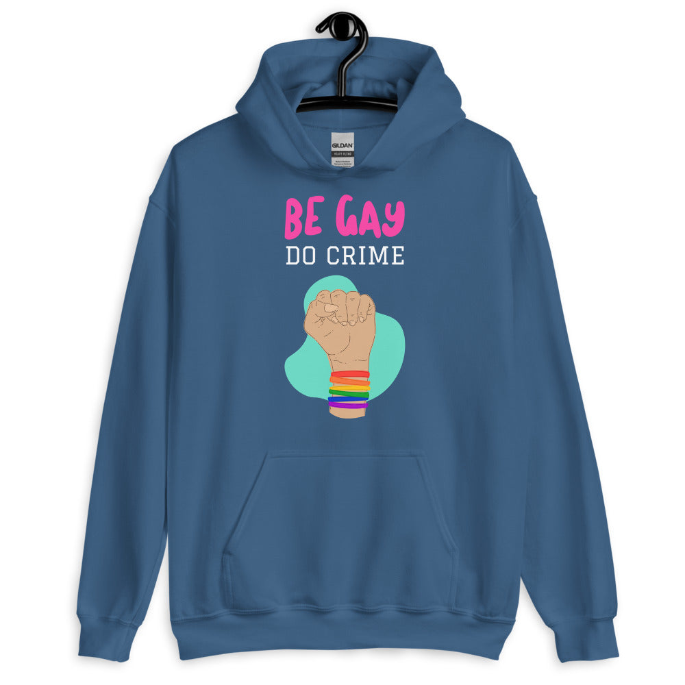 Front view of a blue hoodie reading “BE GAY DO CRIME” with a raised fist and rainbow bracelets