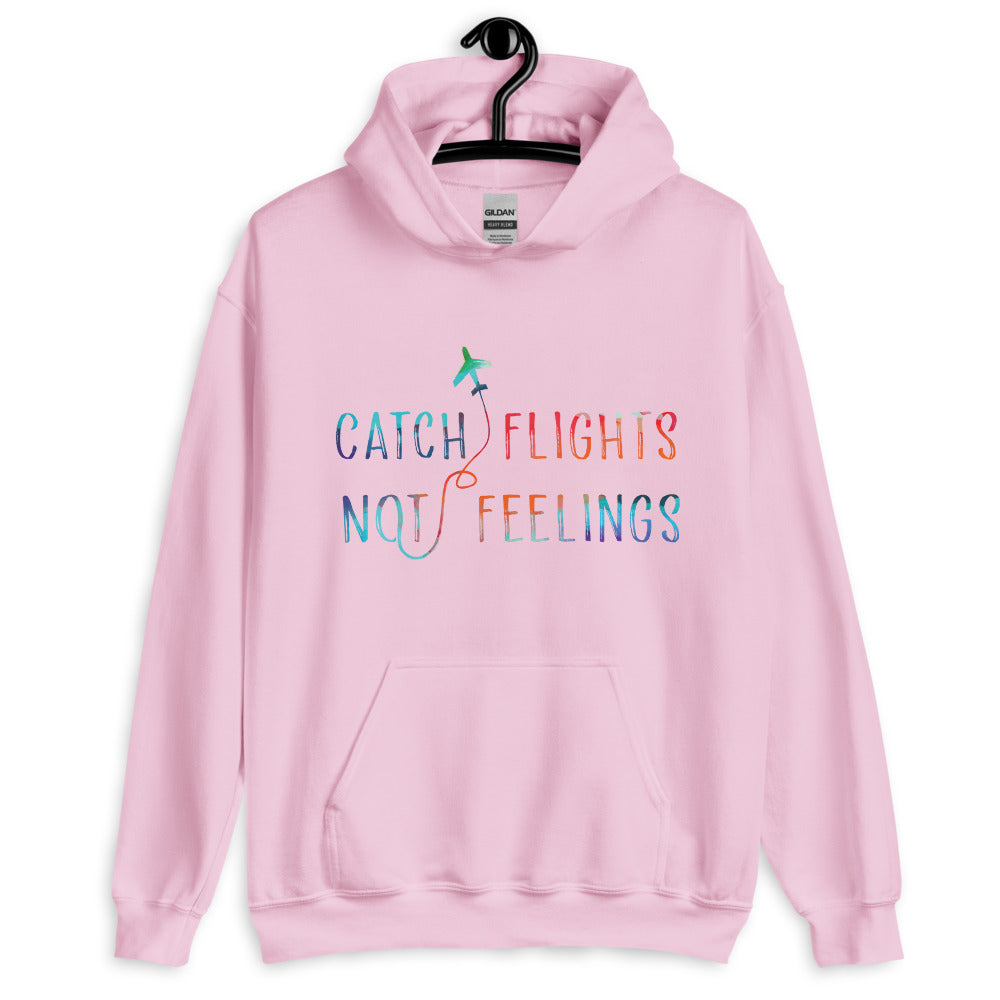 Front view of a light pink hoodie reading “CATCH FLIGHTS NOT FEELINGS” with a plane graphic