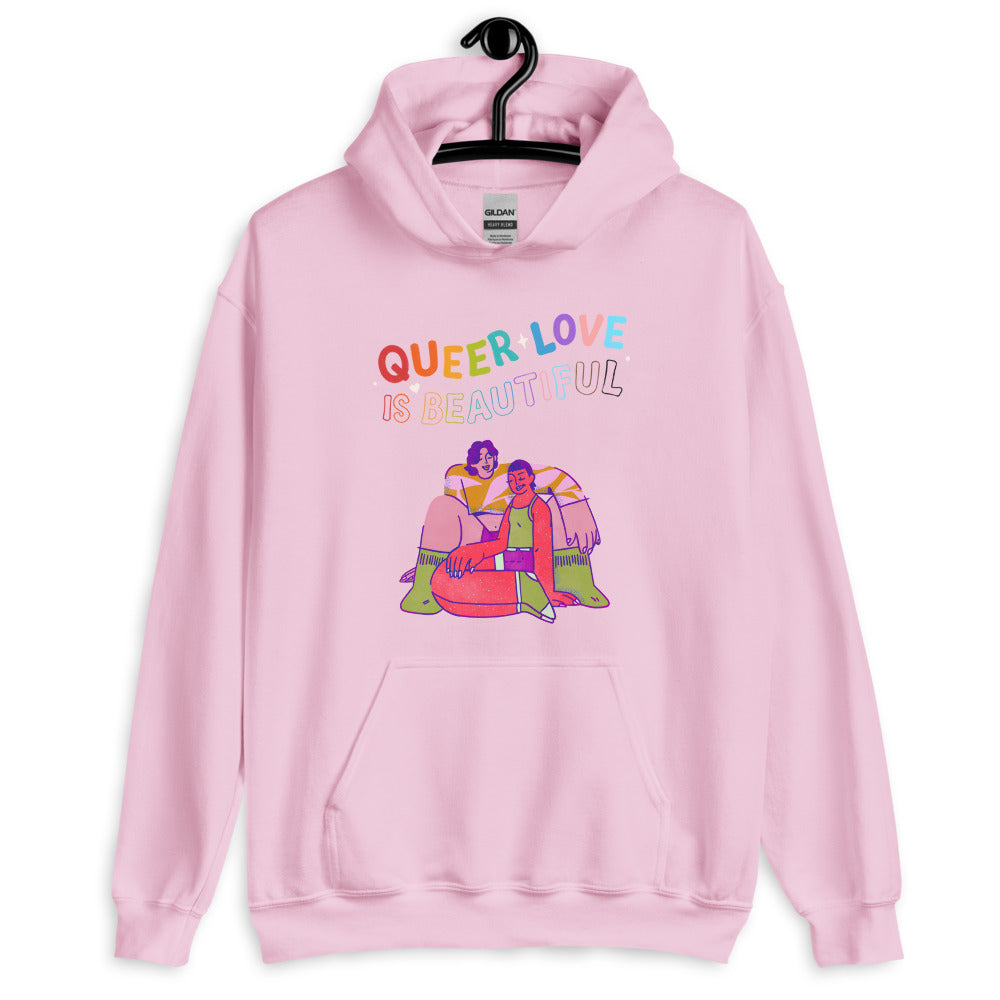 Front view of a pink hoodie reading “QUEER LOVE IS BEAUTIFUL,” with an illustration of two people