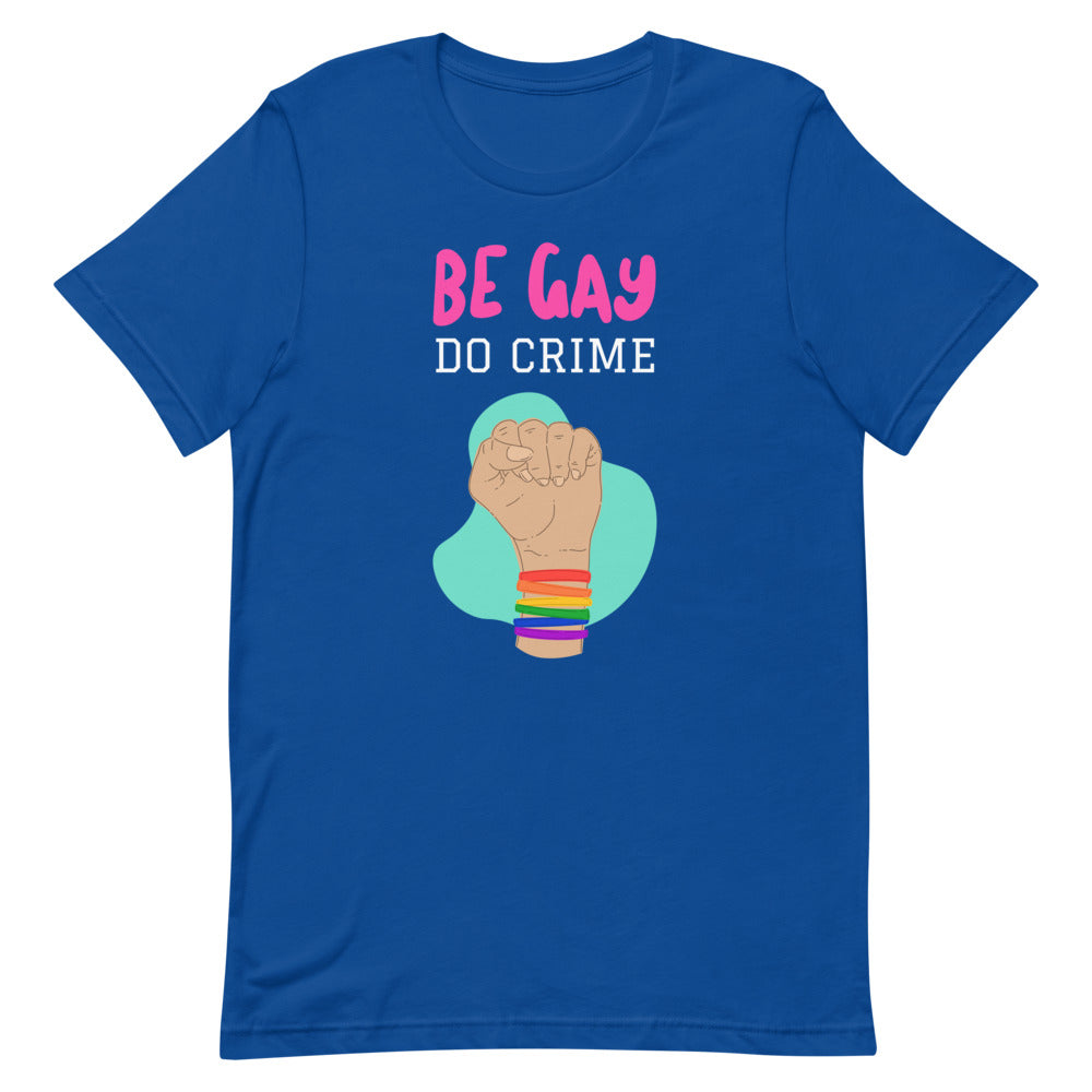 Front view of a royal-blue T-shirt reading “BE GAY DO CRIME,” with a raised fist in rainbow bracelets.