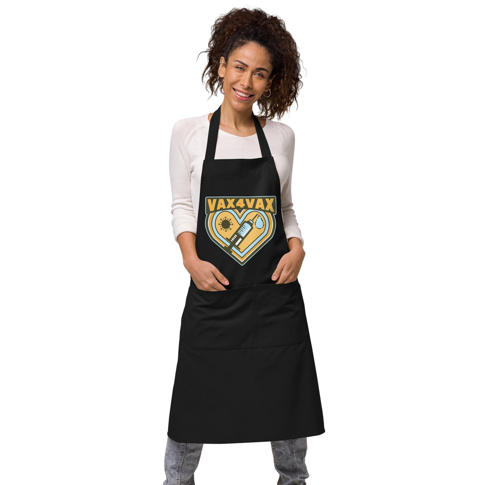Front view of a model wearing a black apron with a “VAX 4 VAX” heart-and-syringe graphic