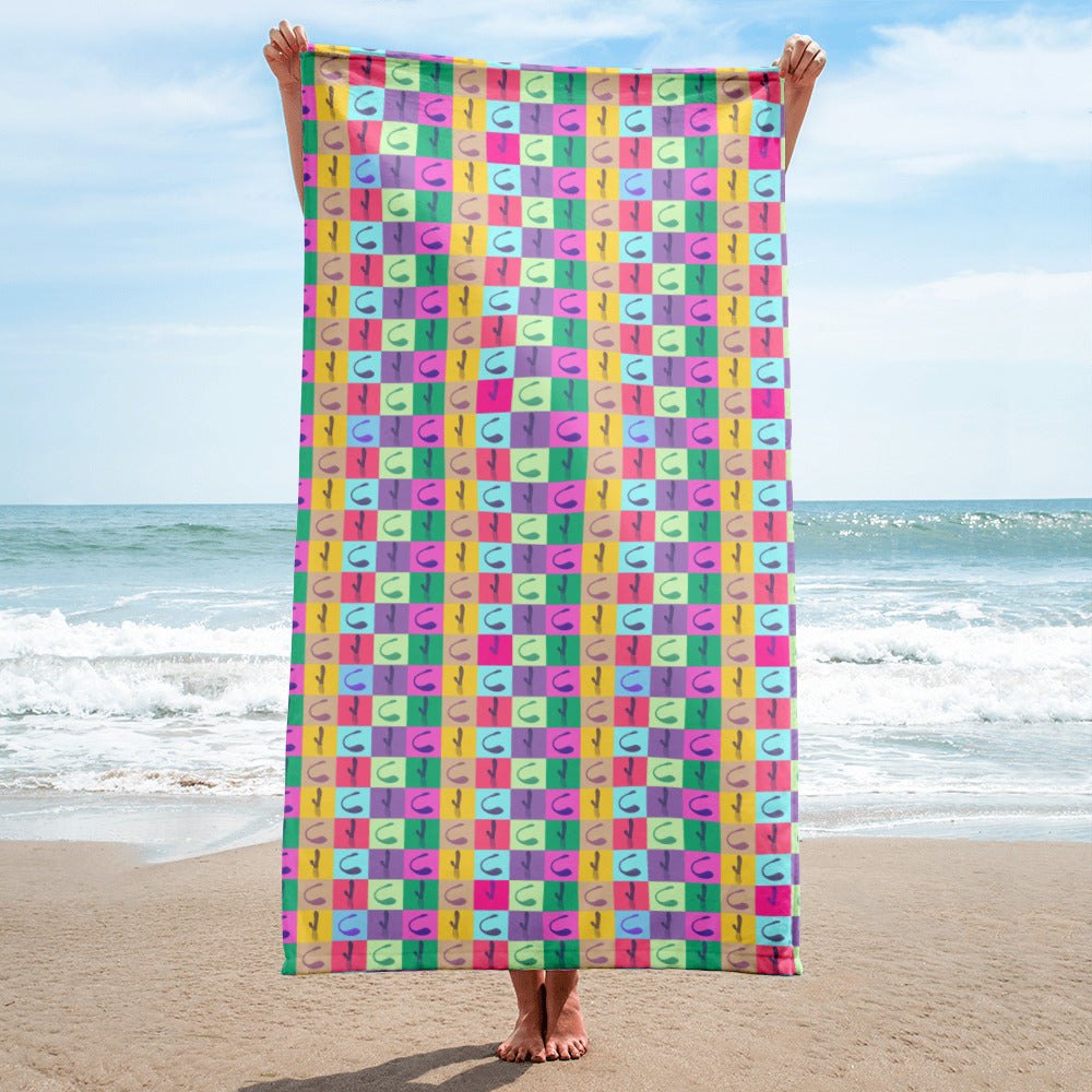 Person holding a colorful vibrator-pattern beach towel on a sunny beach