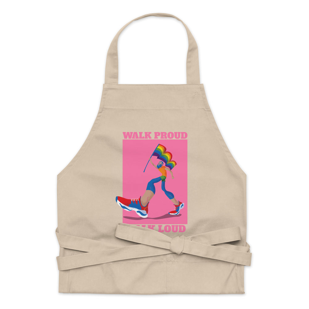 Front view of a beige apron with pink “WALK PROUD” and “WALK LOUD” text and rainbow illustration