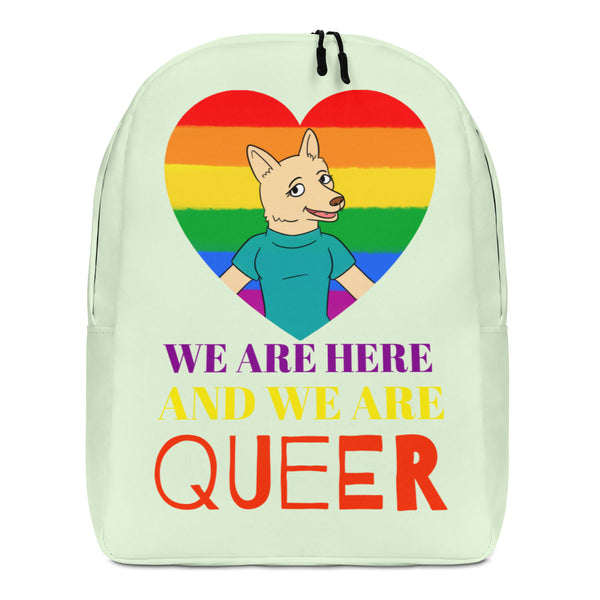 Front view of a pale green backpack with a rainbow heart and cartoon wolf, reading “WE ARE HERE AND WE ARE QUEER.”