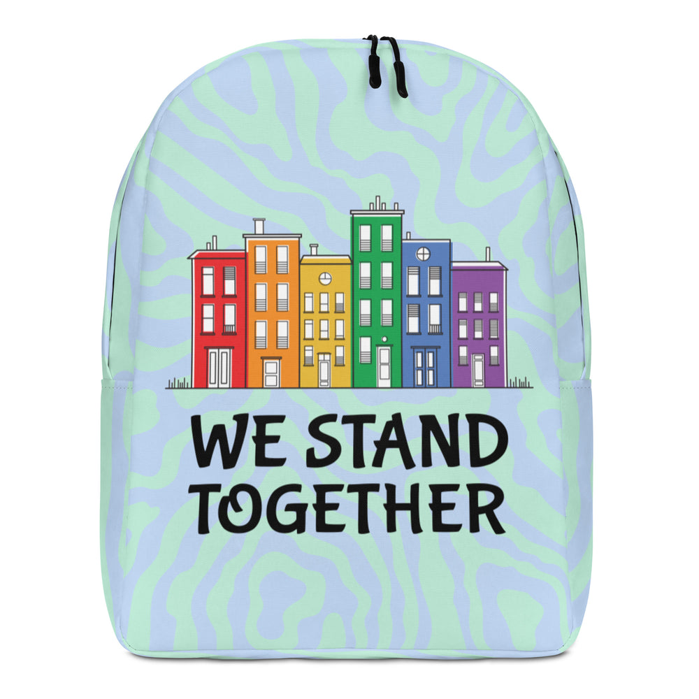 Front-facing pastel backpack with colorful row houses and “WE STAND TOGETHER” lettering