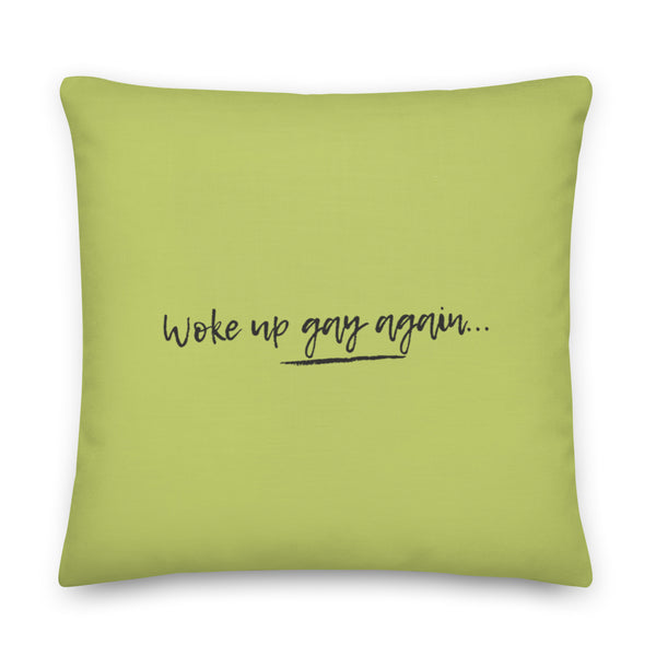 Front-facing lime green square pillow reading “woke up gay again…” in black script