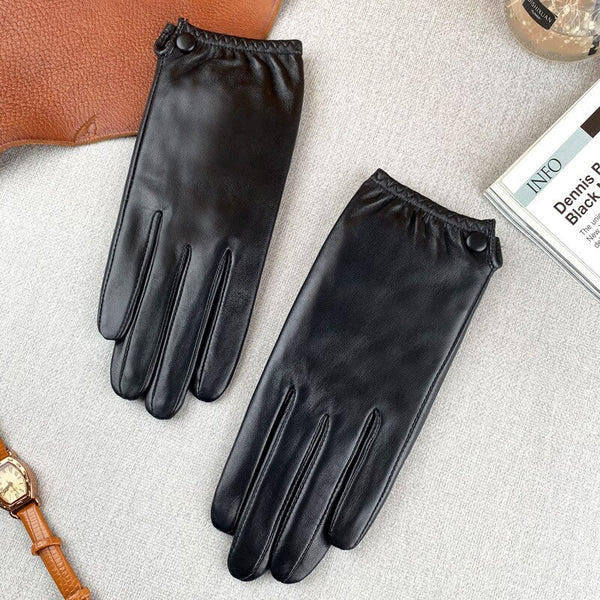 Pair of black leather gloves laid flat, showing stitched fingers and snap-button cuffs