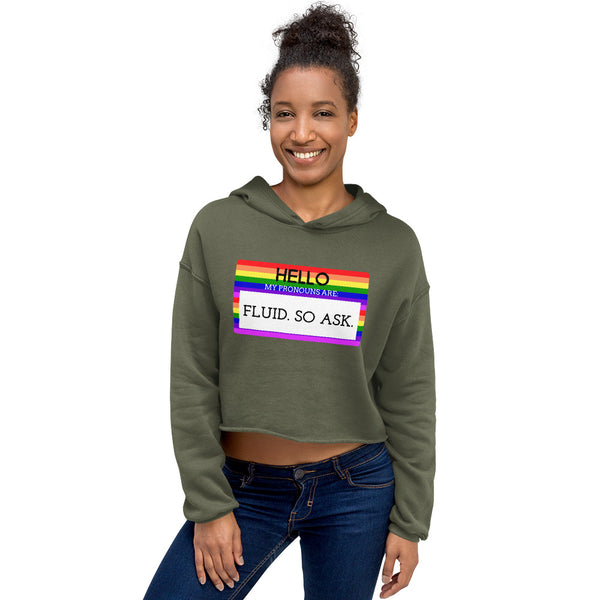 Model wearing an olive cropped hoodie with a rainbow-bordered pronoun message reading “HELLO MY PRONOUNS ARE FLUID. SO ASK.”
