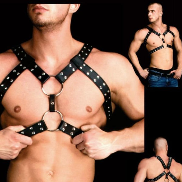 Close-up of a black leather chest harness with silver studs, O-rings and crossing straps