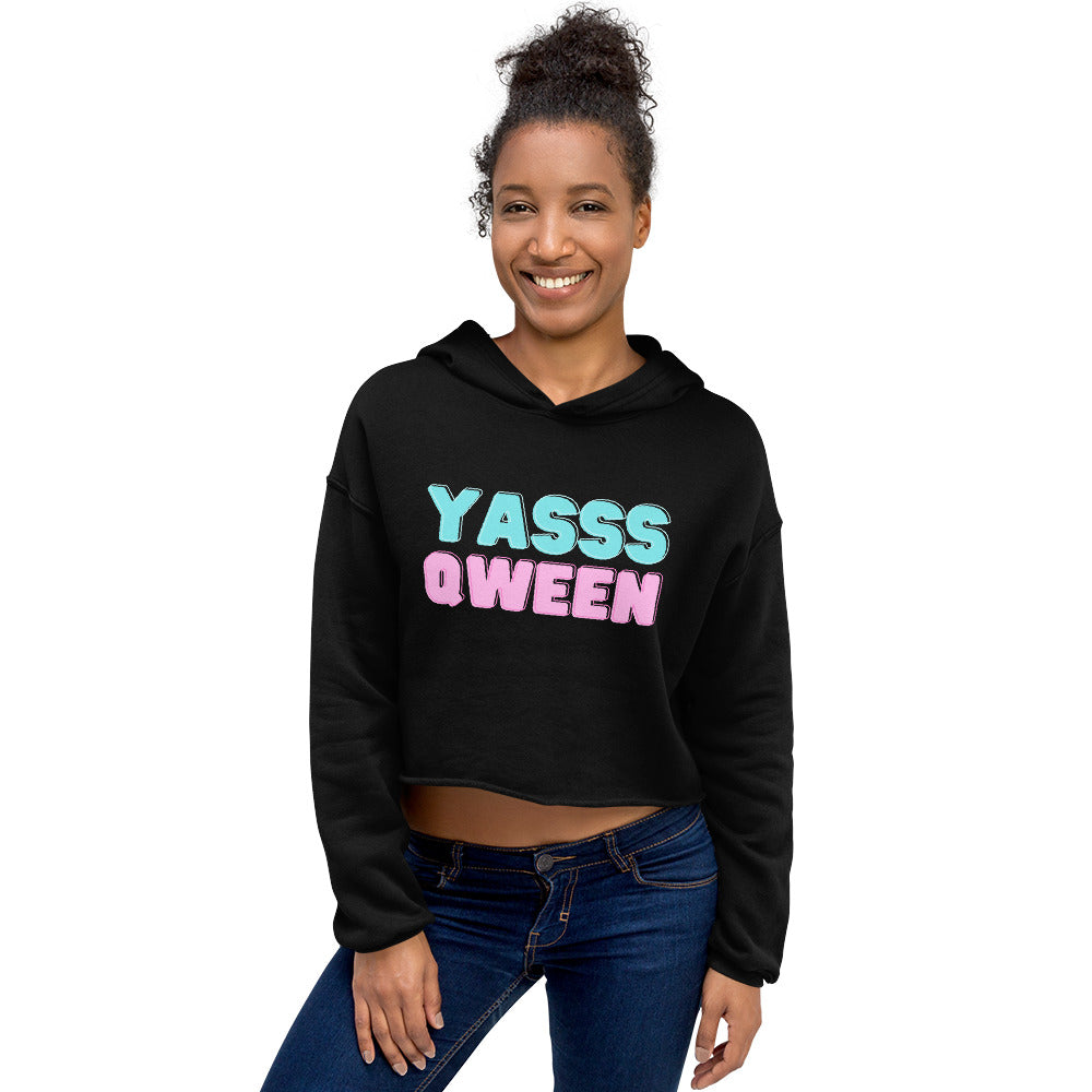 Model wearing a black cropped hoodie with pastel “YASSS QWEEN” lettering