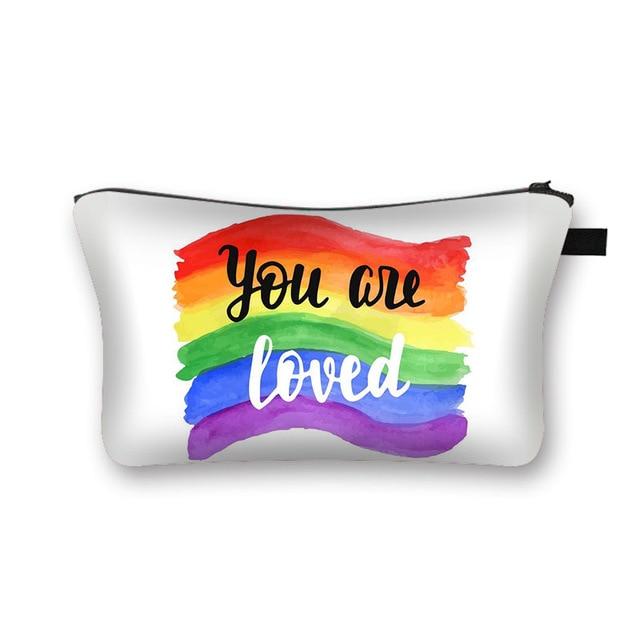 White cosmetic pouch with rainbow brushstroke stripes and “You are Loved” lettering