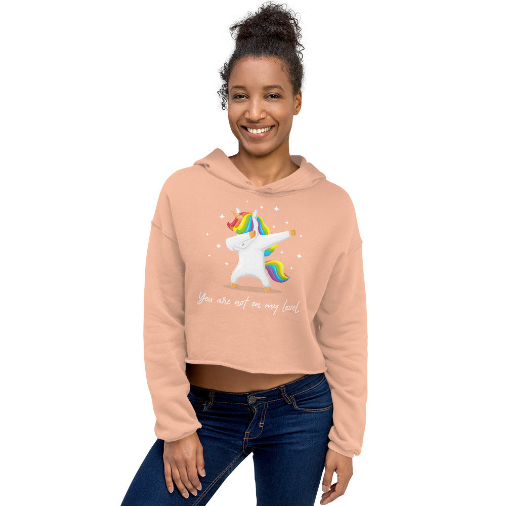 Model wearing a peach cropped hoodie with a colorful dancing unicorn and “You are not on my level” text