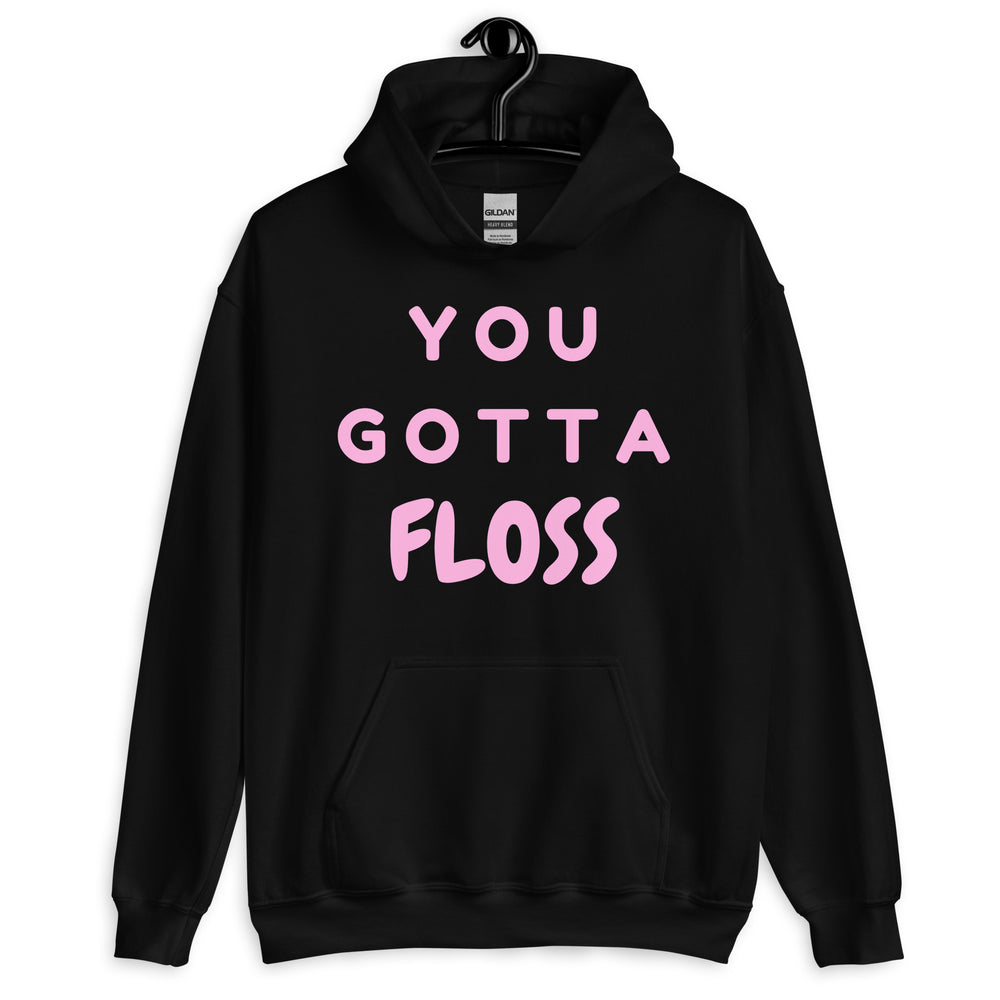 Front view of a black pullover hoodie with pink “YOU GOTTA FLOSS” lettering