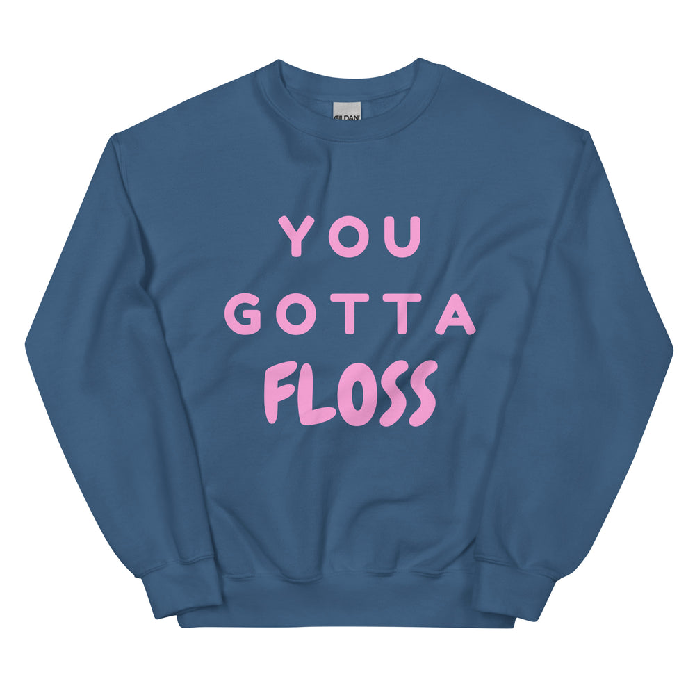 Front view of a blue crewneck sweatshirt reading “YOU GOTTA FLOSS” in pink letters